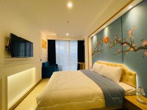 Deluxe Room @ ArtDeco Luxury Hotel & Residence By Parker House في باندونغ: غرفة نوم بسرير وجدار ازرق