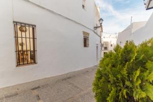 un edificio bianco con una finestra su una strada di Casa La Favorita a Vejer de la Frontera
