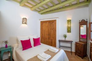 una camera da letto con un letto con cuscini rossi di Casa La Favorita a Vejer de la Frontera
