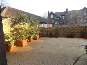 une terrasse avec des plantes en pot et une clôture en bois dans l'établissement The Mountford Hotel - Free Parking, à Liverpool