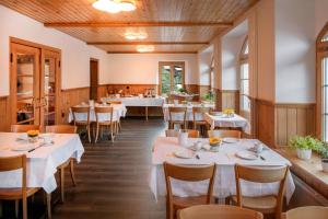 Hotel Breithorn في Blatten im Lötschental: غرفة طعام مع طاولات وكراسي بيضاء