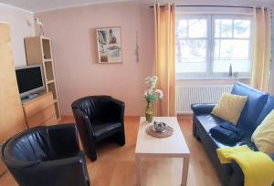 een woonkamer met een bank, 2 stoelen en een tafel bij Ostseestrand in Juliusruh