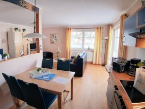 eine Küche und ein Wohnzimmer mit einem Tisch und Stühlen in der Unterkunft Ostseestrand in Juliusruh
