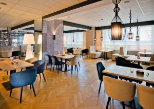 restauracja z drewnianymi stołami i krzesłami oraz stolikiem stołowym w obiekcie Sanatorium Uzdrowiskowe LECH w Kołobrzegu