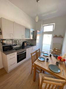 a kitchen with a wooden table with chairs and a dining room at RB City Apartments Emden am Wall 2 in Emden