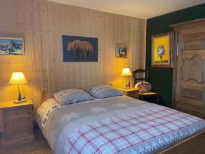 a bedroom with a bed with two lamps and two chairs at Sirolane, chalet au bord des pistes au Sauze in Enchastrayes