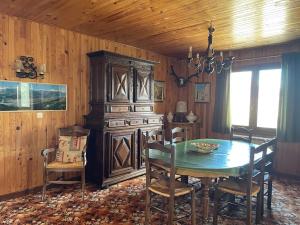 ein Esszimmer mit einem Tisch und einer Holzwand in der Unterkunft Sirolane, chalet au bord des pistes au Sauze in Enchastrayes