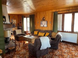 ein Wohnzimmer mit einem Sofa, Stühlen und einem Tisch in der Unterkunft Sirolane, chalet au bord des pistes au Sauze in Enchastrayes