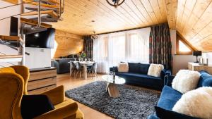 a living room with a blue couch and a table at Aparthotel Delta Zakopane in Zakopane