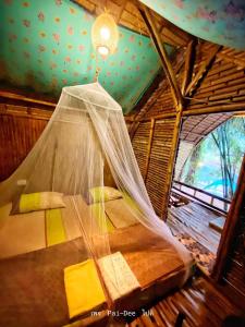 een bed in een kamer met een net bij KRABI BAMBOO KINGDOM at AOLUEK PARADISE in Ao Luk