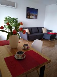 sala de estar con mesa y sofá azul en APARTAMENT MARTA, en Biłgoraj