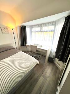 sypialnia z łóżkiem, biurkiem i oknem w obiekcie Comfortable Double Room for One Person w mieście Hither Green