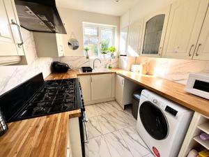 uma cozinha com fogão forno ao lado de uma máquina de lavar louça em Comfortable Double Room for One Person em Hither Green