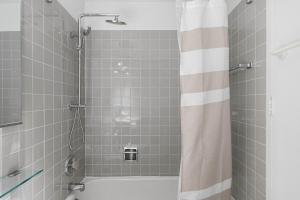 a bathroom with a tub and a shower with a shower curtain at Gold Coast 2BR w Gym Roof nr Water Tower CHI-389 in Chicago +18 photos