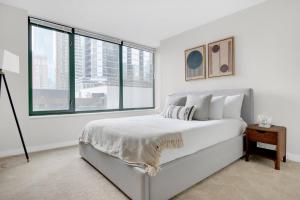 a white bedroom with a bed and a large window at Streeterville 2BR w Deck Gym nr Beach Park CHI-589 in Chicago +35 photos