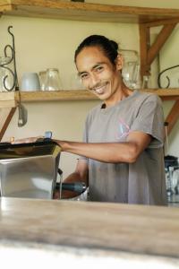un homme debout dans une cuisine préparant la nourriture dans l'établissement Owa Lodge Areguling, à Kuta Lombok