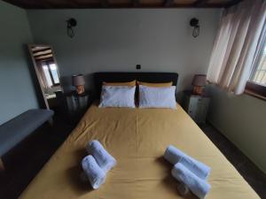 a bedroom with a bed with two pillows on it at Herme's Hut in Pavliani