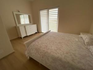 1 dormitorio con 1 cama, vestidor y 2 ventanas en Art villa, en Durrës