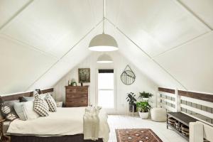a bedroom with a large bed in a attic at The Barn Heathcote in Heathcote