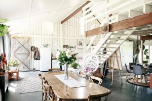 a dining room with a wooden table and chairs at The Barn Heathcote in Heathcote