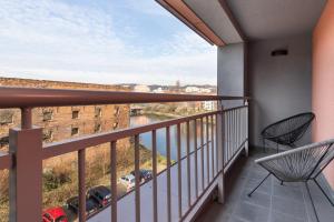a balcony with chairs and a view of the water at Waterlane Apartment SPA&Wellness, Pool by Renters in Gdańsk