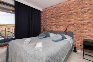 a bedroom with a bed with a brick wall at Waterlane Apartment SPA&Wellness, Pool by Renters in Gdańsk