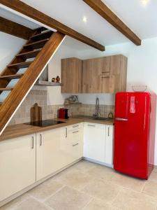 una cocina con nevera roja y una escalera en Charmante maison de village, en Olmeto
