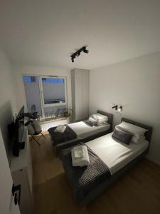 een slaapkamer met 2 bedden en een televisie. bij APARTAMENT 4 bed 2 room WARSAW in Warschau
