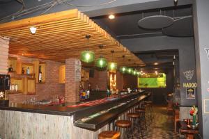 a bar in a restaurant with a row of stools at Kyriad Hotel Indore by OTHPL in Indore