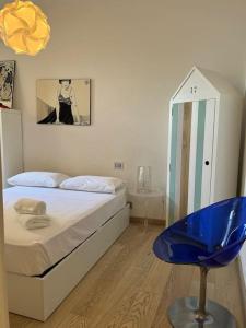 um quarto com uma cama e uma cadeira azul em Village Médiévale, superbe appartement vu mer et Monaco em Roquebrune-Cap-Martin