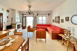 a living room with a red couch and a table at Irini Traditional House Afitos in Afitos