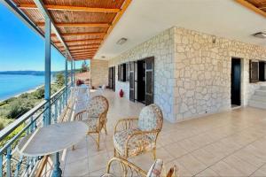a balcony with a table and chairs and the ocean at Irini Traditional House Afitos in Afitos