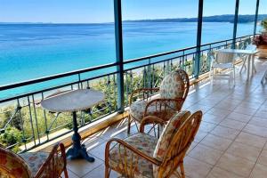 a balcony with chairs and a table and the ocean at Irini Traditional House Afitos in Afitos