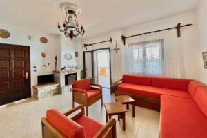 a living room with a red couch and a fireplace at Irini Traditional House Afitos in Afitos +12 photos