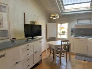 uma cozinha com uma mesa e uma televisão numa cómoda em Casa161 em Bolonha