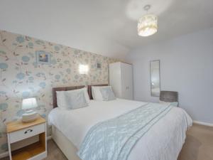 a bedroom with a large bed and a night stand with a lamp at Apartment 7 - 1 bedroom Sea front location - Step free access from rear - Free Parking in Paignton