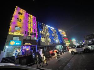 a lit up building on a city street at night at Hotel Areeba by The Golden Taj Group & Hotels in Agra