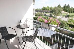 een balkon met stoelen en een tafel en bloemen bij Apartmánový dům na kolonádě in Lednice