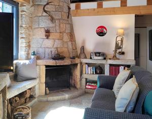 a living room with a stone fireplace with two blue chairs at El Chalet de Navacerrada in Navacerrada
