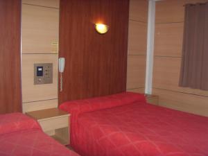 a hotel room with two beds and a phone at Hotel Embajador in Rosario