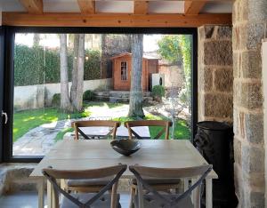 a wooden table with four chairs and a large window at El Chalet de Navacerrada in Navacerrada