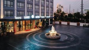 a fountain in the middle of a street in front of a building at Laike Hotel in Bangkok