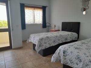 a bedroom with two beds and a window at Residence 1000 Roses in Moncarapacho +29 photos