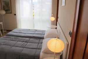 ein Schlafzimmer mit einem Bett und einer Lampe in der Unterkunft EasyRoom Schio in Schio