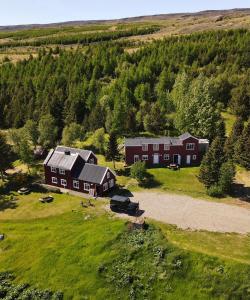 an aerial view of a large red house in a field at Hengifosslodge Skáldahús in Egilsstadir
