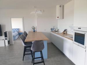 a kitchen with a wooden table and some chairs at Apartament Pod Żaglami in Zegrze Południowe