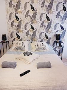 a bedroom with a bed with two remote controls on it at maison spacieuse centre et plage in Brest