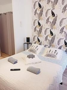 - un lit blanc avec des oreillers et une télécommande dans l'établissement maison spacieuse centre et plage, à Brest