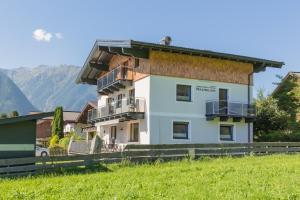 a house in a field with mountains in the background at Apartmenthaus Maximilian in Neukirchen am Großvenediger