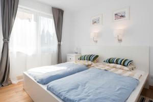 グダニスクにあるApartamenty Apartinfo - Blue Side Familyのベッドルーム1室(隣り合わせのベッド2台付)